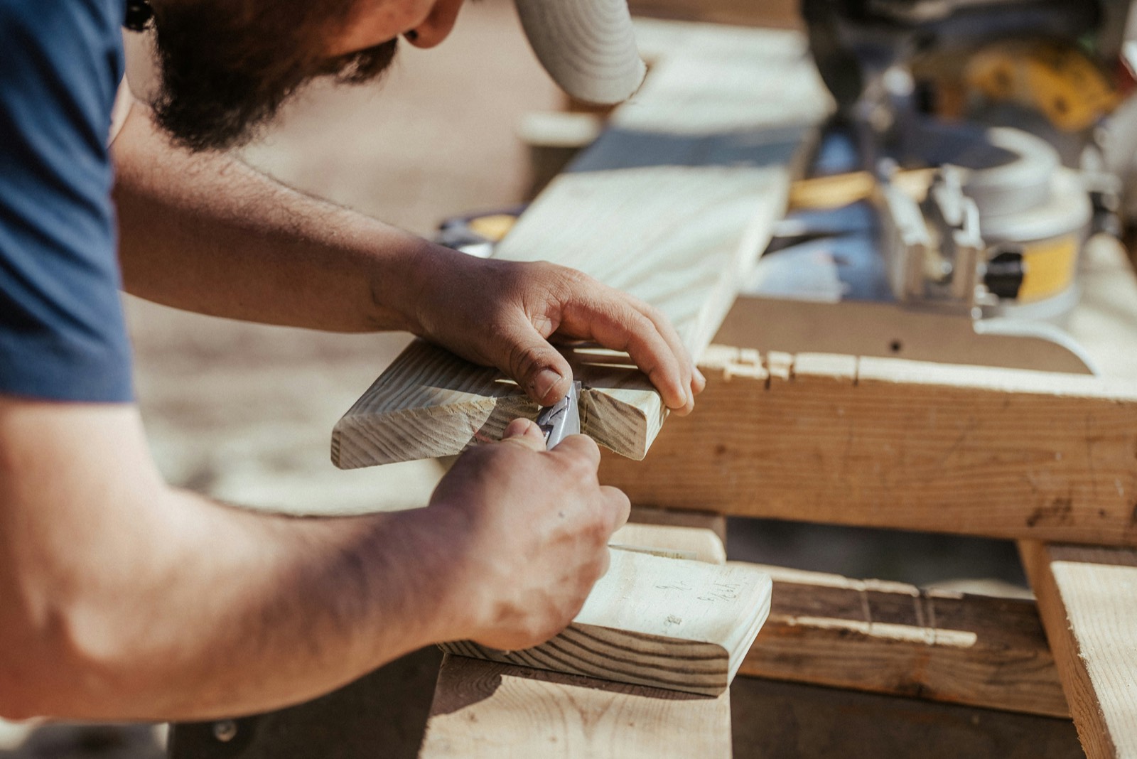 Hands measuring a piece of lumber