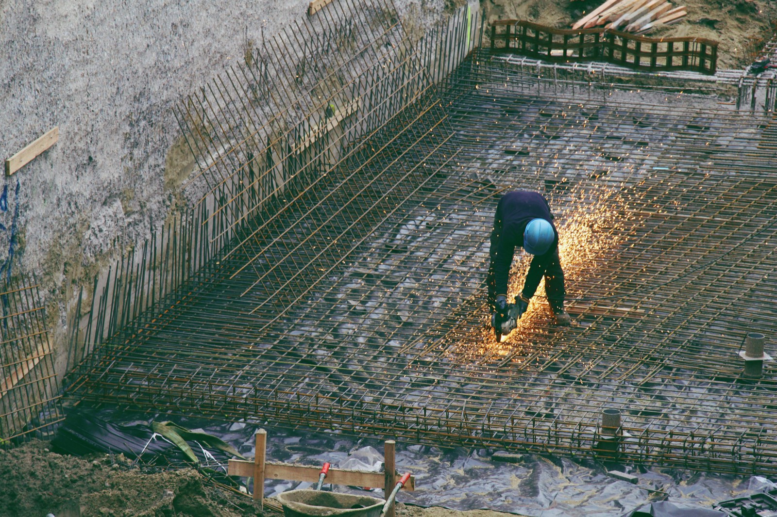 Worker cutting rebar with sparks