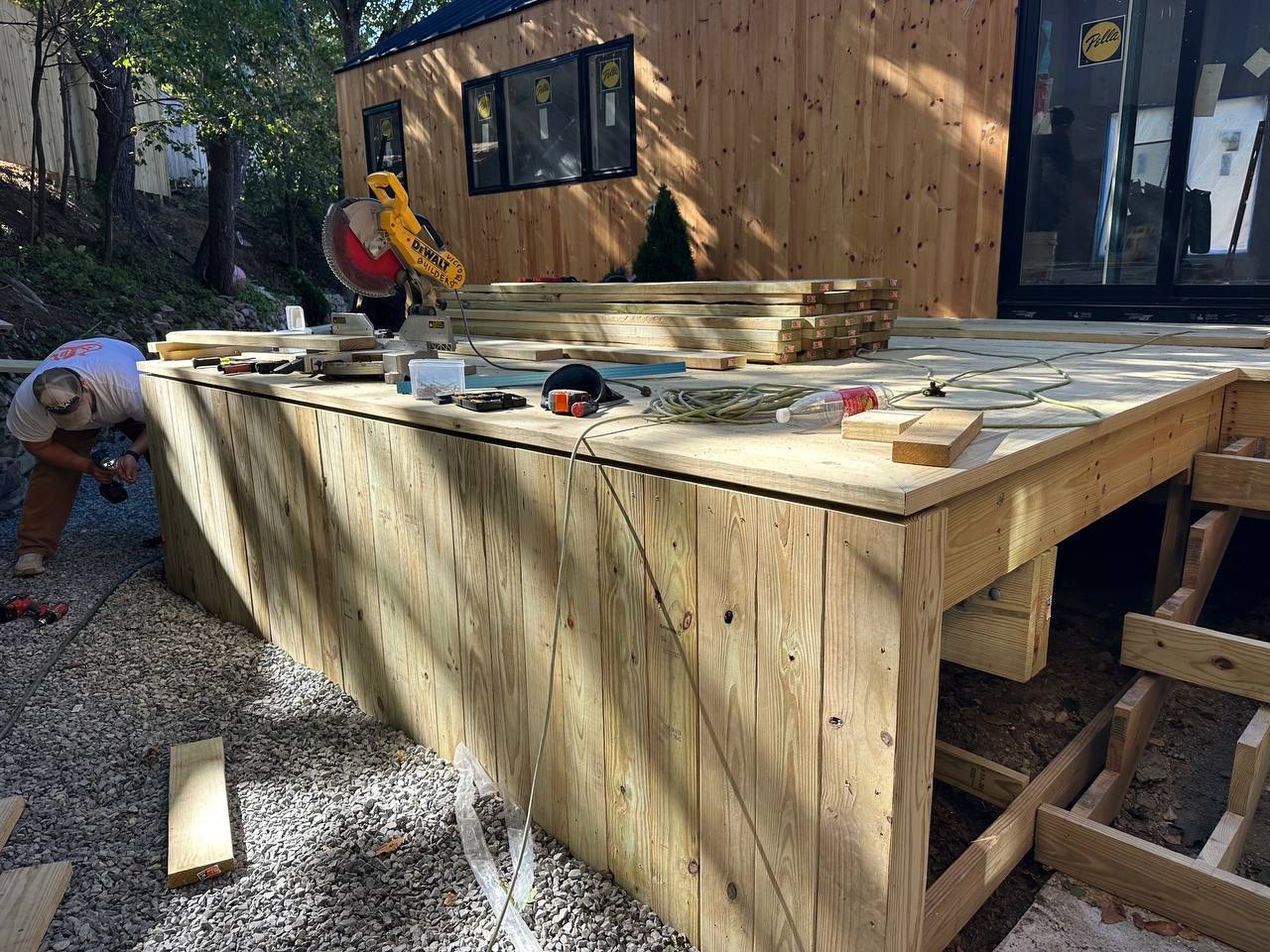 Wood deck under construction against the pine siding