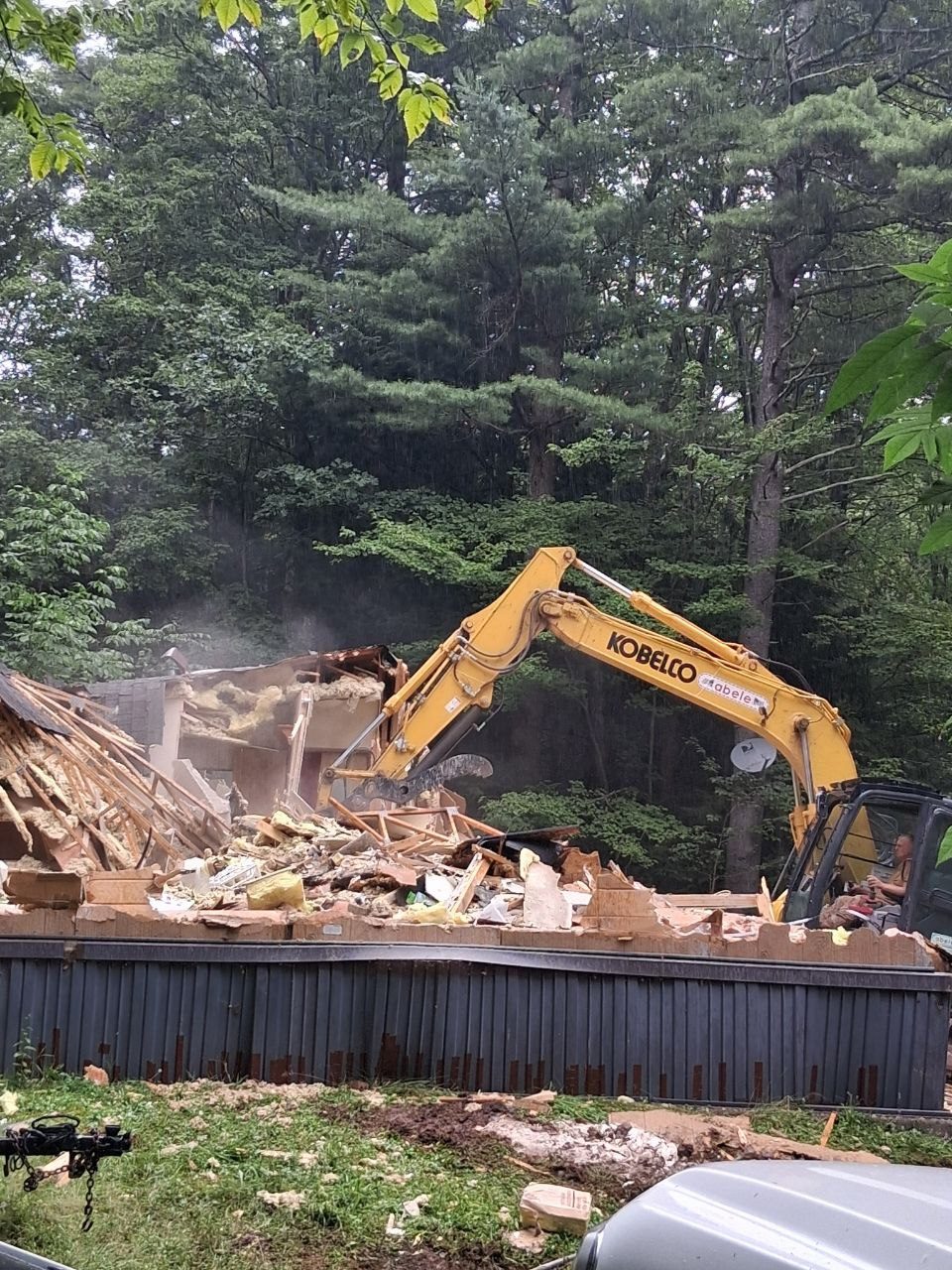 Excavator taking down the existing house