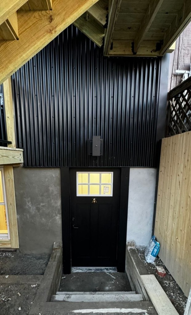 New basement door under the deck during construction