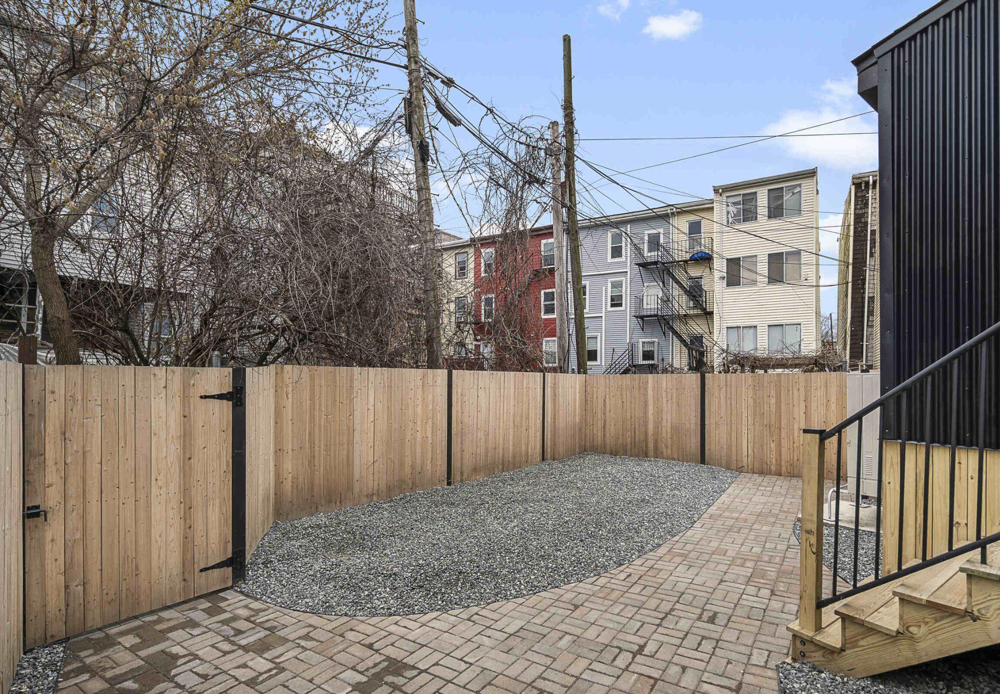 Fenced rear patio with gravel and brick